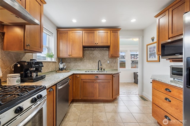 814 E Wright Ave, Tacoma, WA 98404 - kitchen with stainless steel appliances, extractor fan, brown cabinets, light stone countertops, and recessed lighting