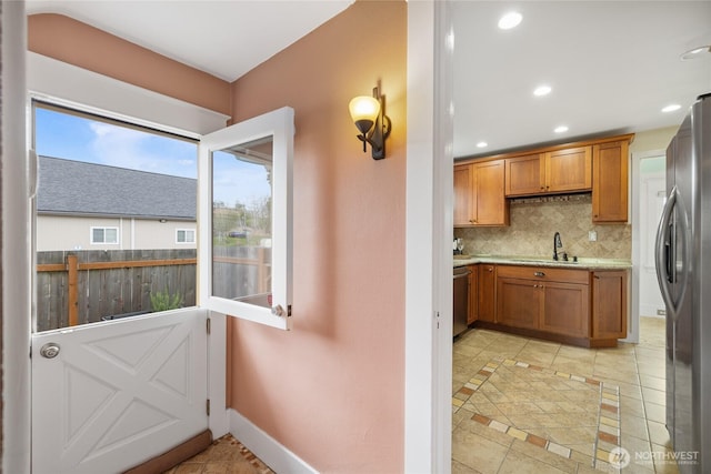 814 E Wright Ave, Tacoma, WA 98404 - kitchen with appliances with stainless steel finishes, backsplash, brown cabinetry, recessed lighting, and light tile patterned flooring