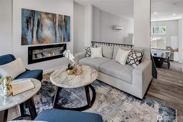 8818 NE 173rd Pl Unit B, Bothell, WA 98011 - living room with wood finished floors, recessed lighting, a glass covered fireplace, and an AC wall unit