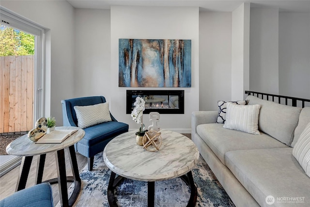 8818 NE 173rd Pl Unit B, Bothell, WA 98011 - living room featuring wood finished floors, a glass covered fireplace, and baseboards