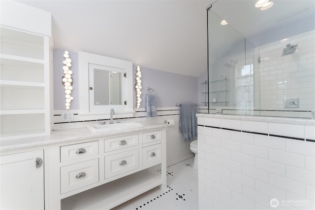 full bathroom with vanity, toilet, tile patterned floors, tile walls, and a stall shower