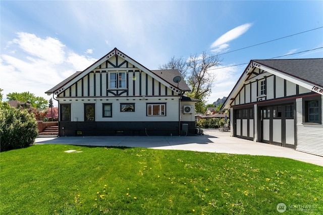 rear view of property featuring a lawn and a garage