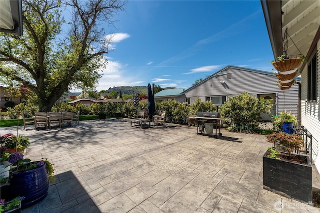 view of patio featuring outdoor dining area, a mountain view, and grilling area