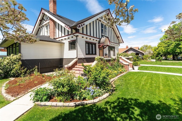 tudor home with board and batten siding, stairs, a chimney, and a front yard