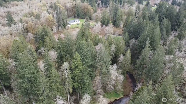 drone / aerial view featuring a wooded view