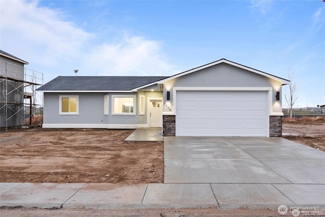single story home with stone siding, driveway, and an attached garage