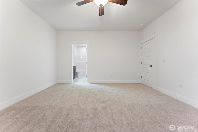 spare room with baseboards, ceiling fan, and light carpet