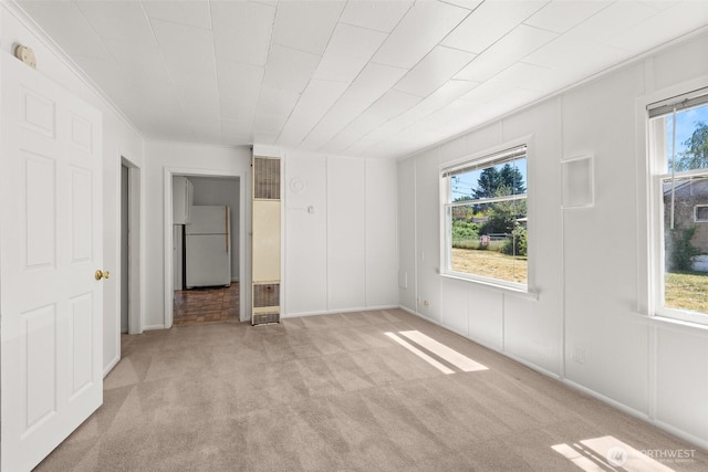 1330 Central Blvd, Centralia, WA 98531 - unfurnished bedroom featuring freestanding refrigerator, a heating unit, multiple windows, and light carpet