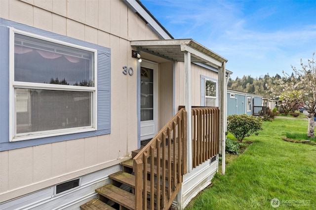 property entrance featuring a lawn