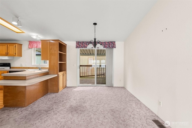 kitchen with light carpet, a notable chandelier, light countertops, and visible vents