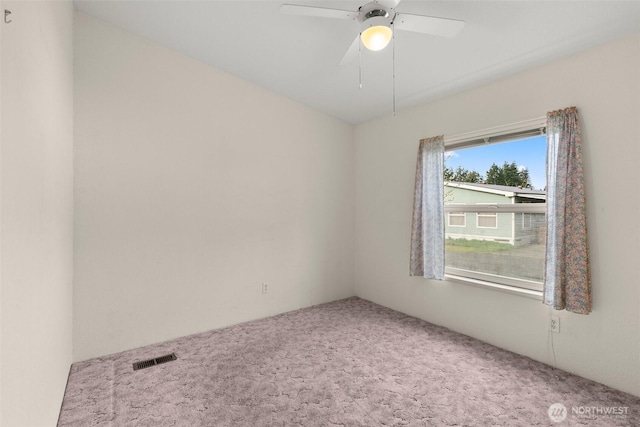 carpeted empty room with ceiling fan and visible vents