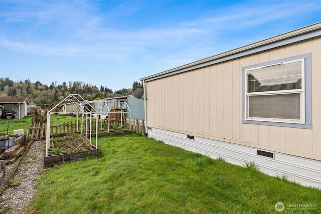 view of yard featuring fence and a vegetable garden