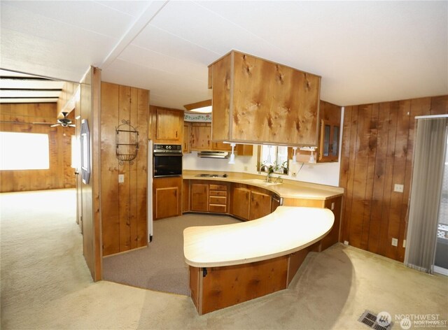 5115 88th Street Ct E Unit 29, Tacoma, WA 98446 - kitchen with a sink, wooden walls, a peninsula, black appliances, and brown cabinets