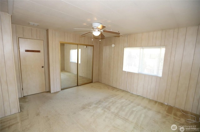 5115 88th Street Ct E Unit 29, Tacoma, WA 98446 - unfurnished bedroom with a closet, wood walls, ceiling fan, and carpet