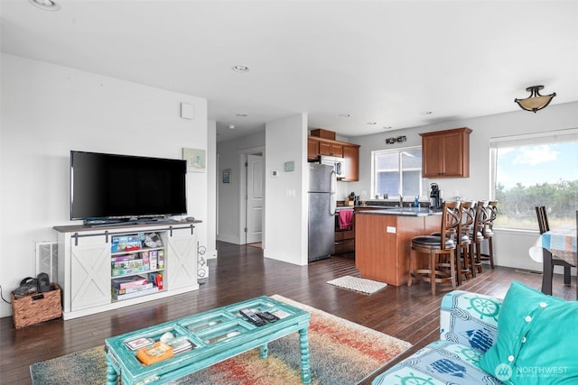 living room with dark wood-type flooring, baseboards, and recessed lighting
