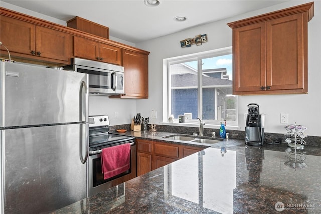 kitchen featuring a sink, stainless steel appliances, and brown cabinetry