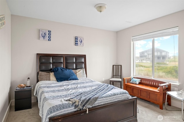 bedroom with light colored carpet and baseboards