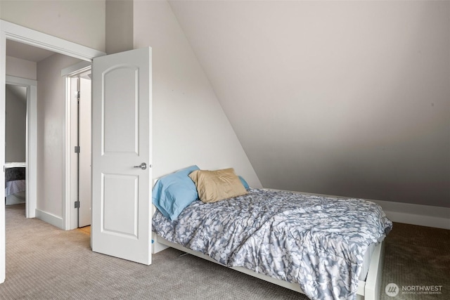carpeted bedroom featuring baseboards and lofted ceiling