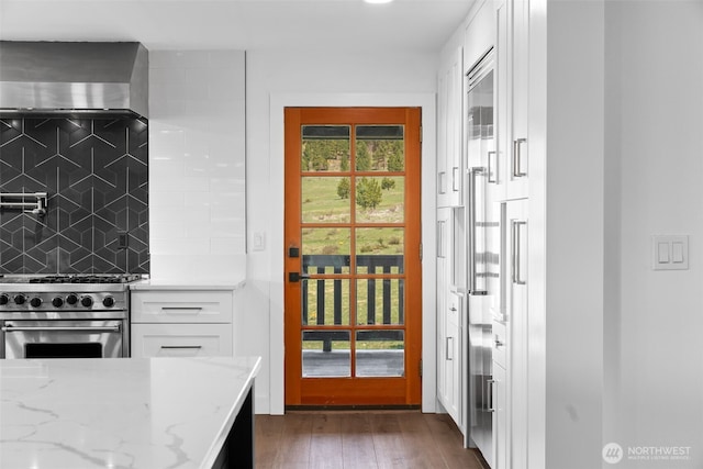 696 Texas Creek Rd, Carlton, WA 98814 - kitchen with decorative backsplash, light stone countertops, white cabinetry, stainless steel range, and wall chimney exhaust hood