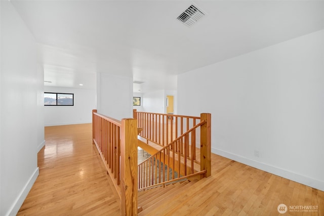 696 Texas Creek Rd, Carlton, WA 98814 - hallway featuring baseboards, visible vents, wood finished floors, and an upstairs landing