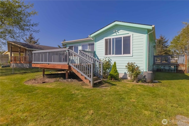 rear view of property with stairs, a yard, and a deck