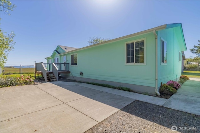 view of home's exterior with a patio area and a wooden deck