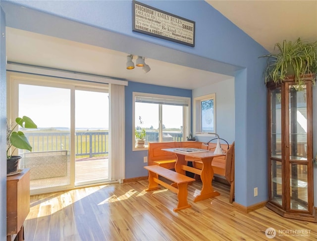 dining area featuring baseboards, vaulted ceiling, and wood finished floors