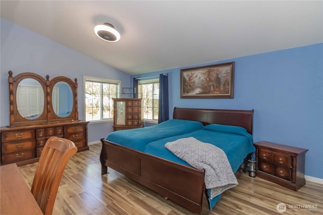 bedroom with baseboards, vaulted ceiling, and wood finished floors