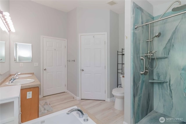 bathroom featuring visible vents, double vanity, a marble finish shower, and wood finished floors