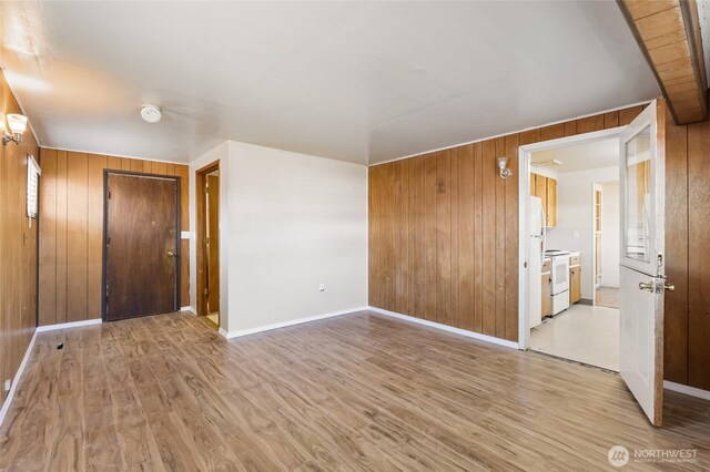 129 G St SE, Ephrata, WA 98823 - empty room with wooden walls, light wood-type flooring, and baseboards
