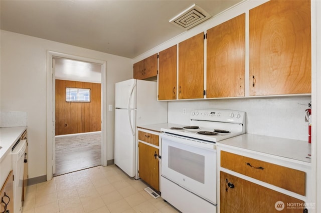 129 G St SE, Ephrata, WA 98823 - kitchen featuring white appliances, light countertops, light floors, baseboards, and brown cabinets