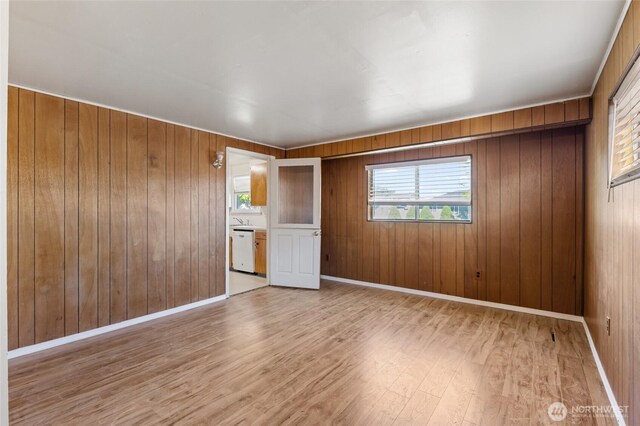 129 G St SE, Ephrata, WA 98823 - empty room featuring healthy amount of natural light, light wood-type flooring, wood walls, and baseboards