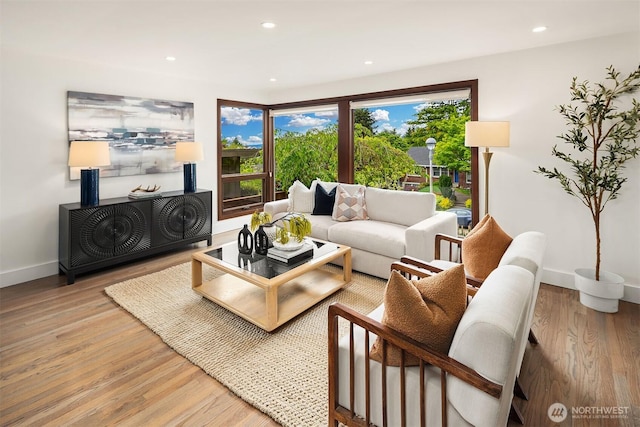 living room featuring light wood-style flooring, plenty of natural light, baseboards, and recessed lighting