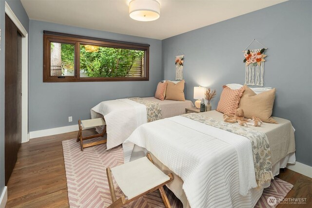 bedroom featuring baseboards, wood finished floors, and a closet