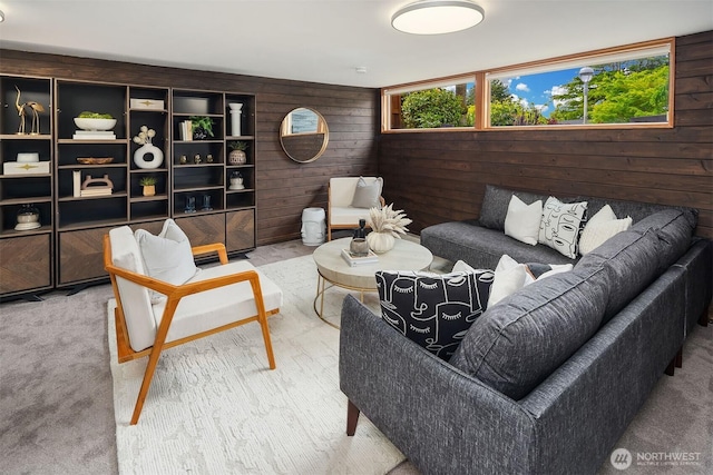 living area featuring wood walls, plenty of natural light, and carpet