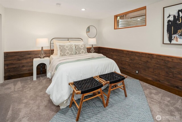 carpeted bedroom with wood walls and wainscoting