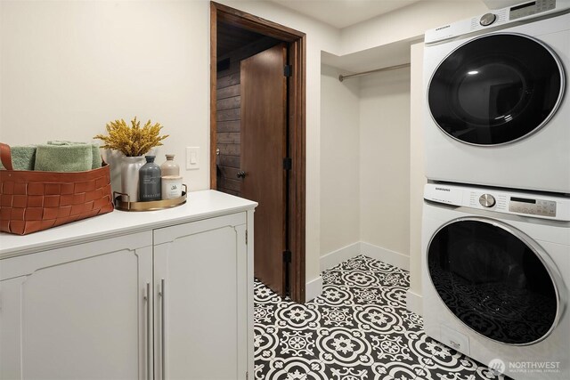 laundry room featuring stacked washer / drying machine and baseboards