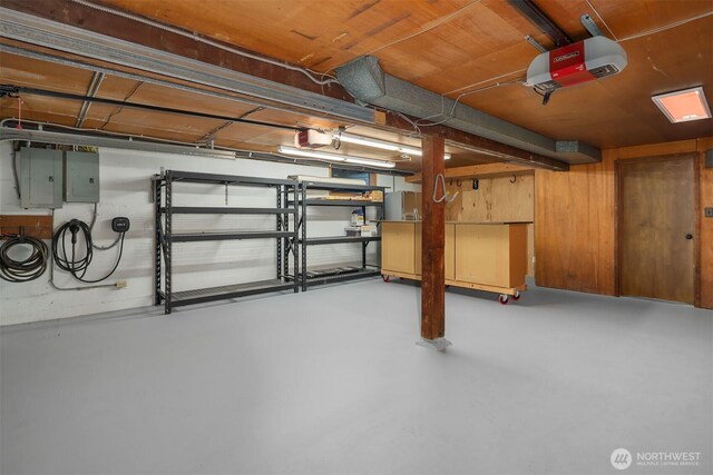 basement featuring electric panel and a garage