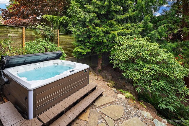 view of pool featuring a hot tub and fence