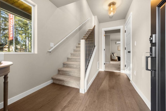 entryway with baseboards, stairs, and wood finished floors