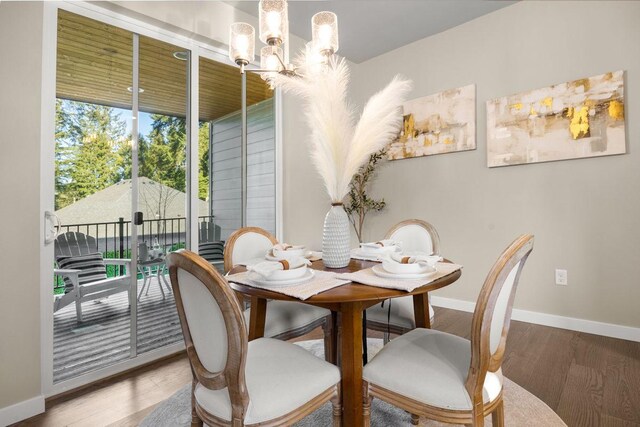 dining room featuring an inviting chandelier, baseboards, and wood finished floors