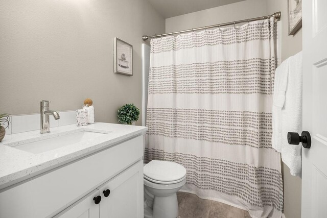 full bath featuring vanity, curtained shower, and toilet