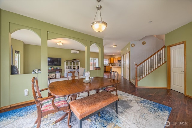 1006 Cathleen St, Port Angeles, WA 98363 - dining area with stairway, hardwood / wood-style floors, baseboards, arched walkways, and a wall mounted air conditioner