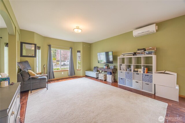 1006 Cathleen St, Port Angeles, WA 98363 - game room with arched walkways, baseboards, a wall mounted air conditioner, and wood finished floors