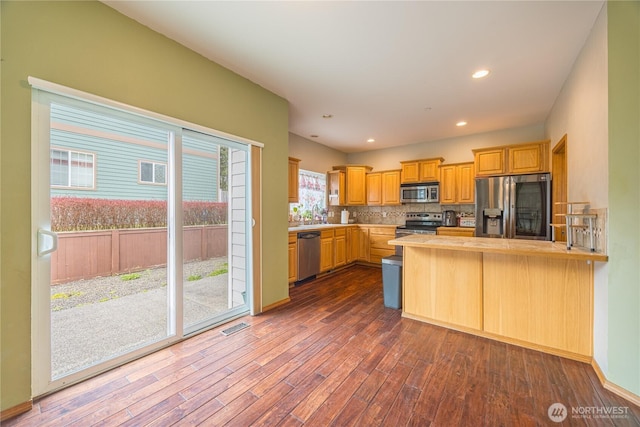 1006 Cathleen St, Port Angeles, WA 98363 - kitchen featuring light countertops, a peninsula, dark wood-style floors, stainless steel appliances, and decorative backsplash