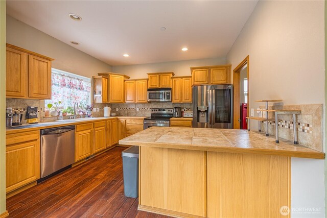 1006 Cathleen St, Port Angeles, WA 98363 - kitchen with a sink, a peninsula, dark wood-style floors, stainless steel appliances, and decorative backsplash