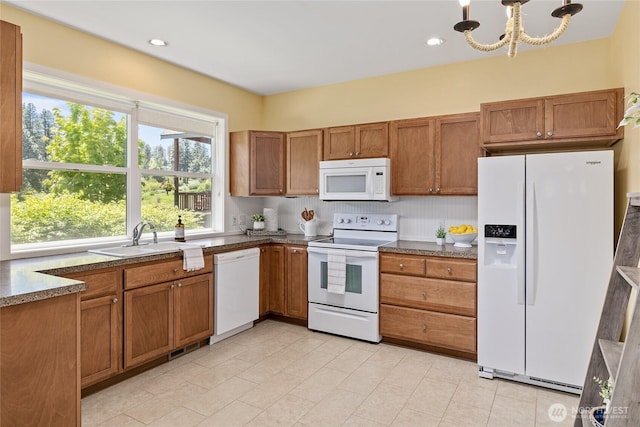 1140 Twin Lakes Rd, Cle Elum, WA 98922 - kitchen with white appliances, a sink, brown cabinets, a chandelier, and light tile patterned floors