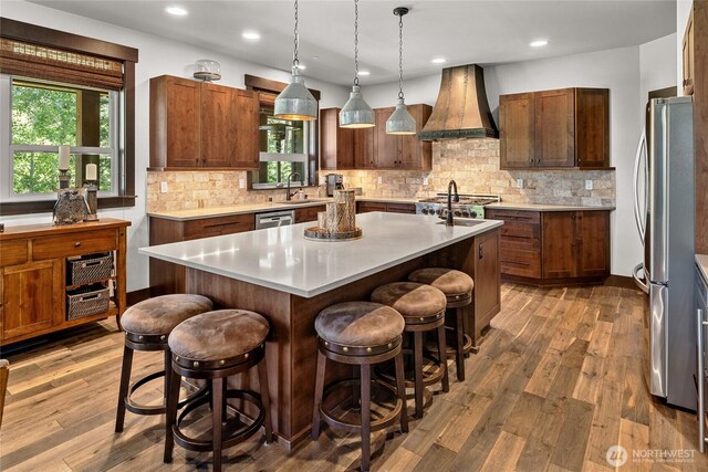 31 Powder Cap Ct, Cle Elum, WA 98922 - kitchen with light countertops, appliances with stainless steel finishes, premium range hood, a kitchen breakfast bar, and a center island with sink