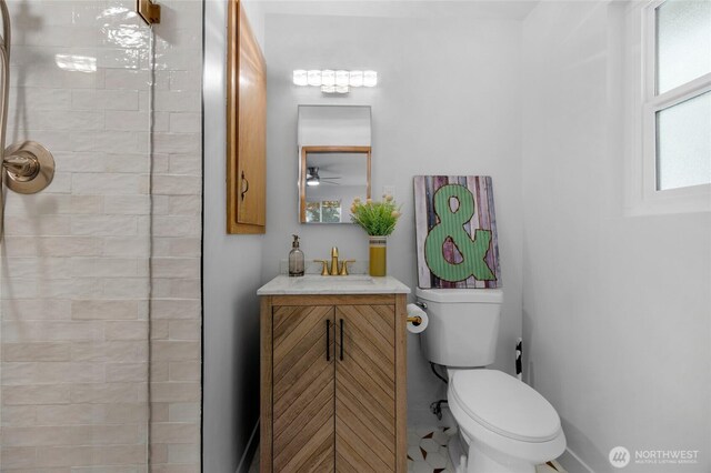 bathroom featuring vanity, a ceiling fan, toilet, and tiled shower