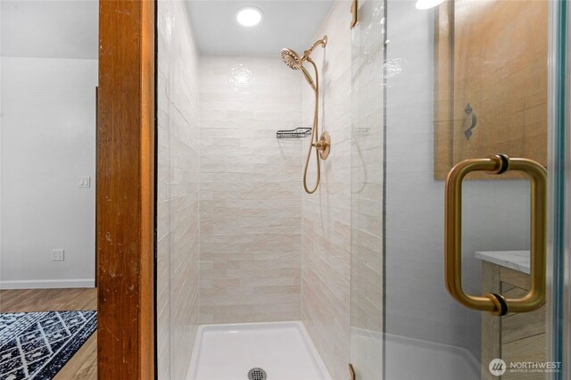 full bathroom with a shower stall and wood finished floors